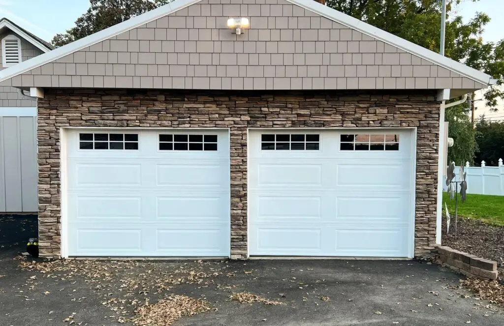 Small double white garage door installation with 2x8 windows.